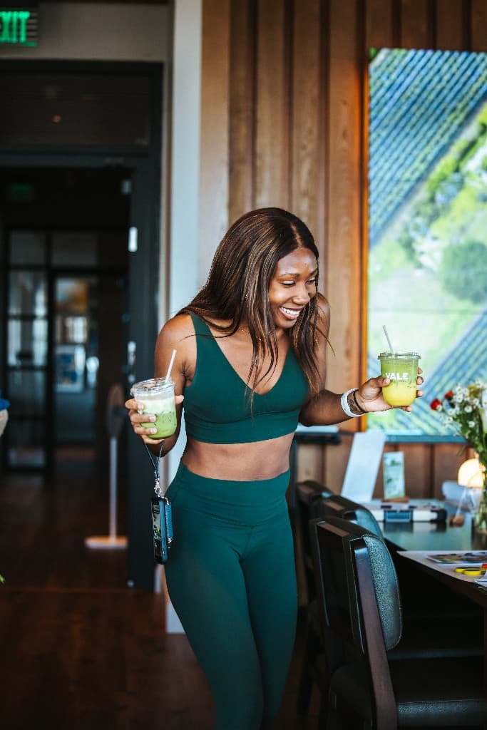 A guest walking with two Vale matcha drinks