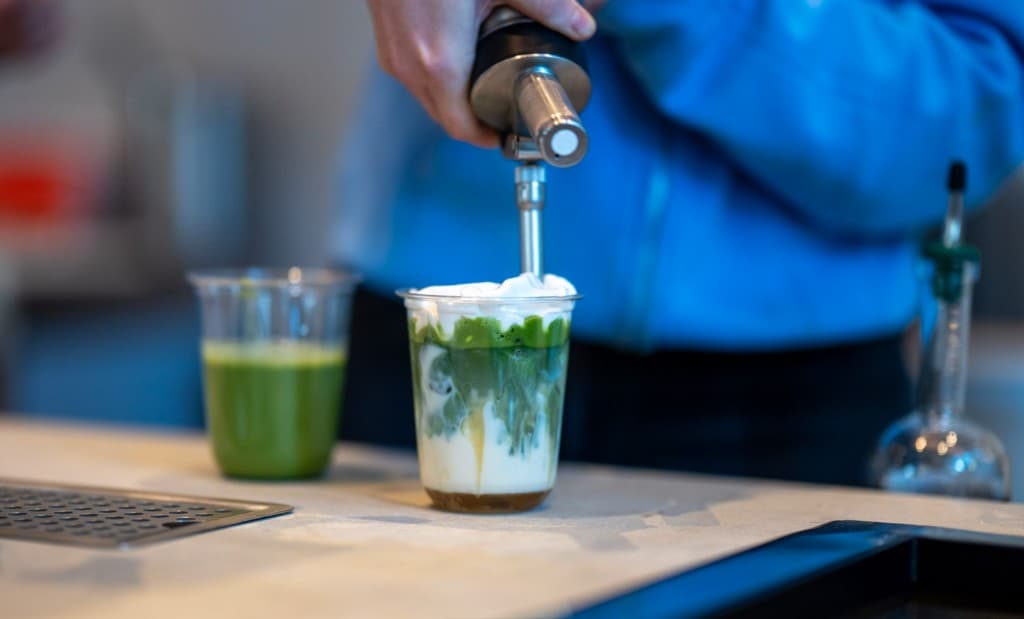 A Vale matcha being finished with foam at the cafe