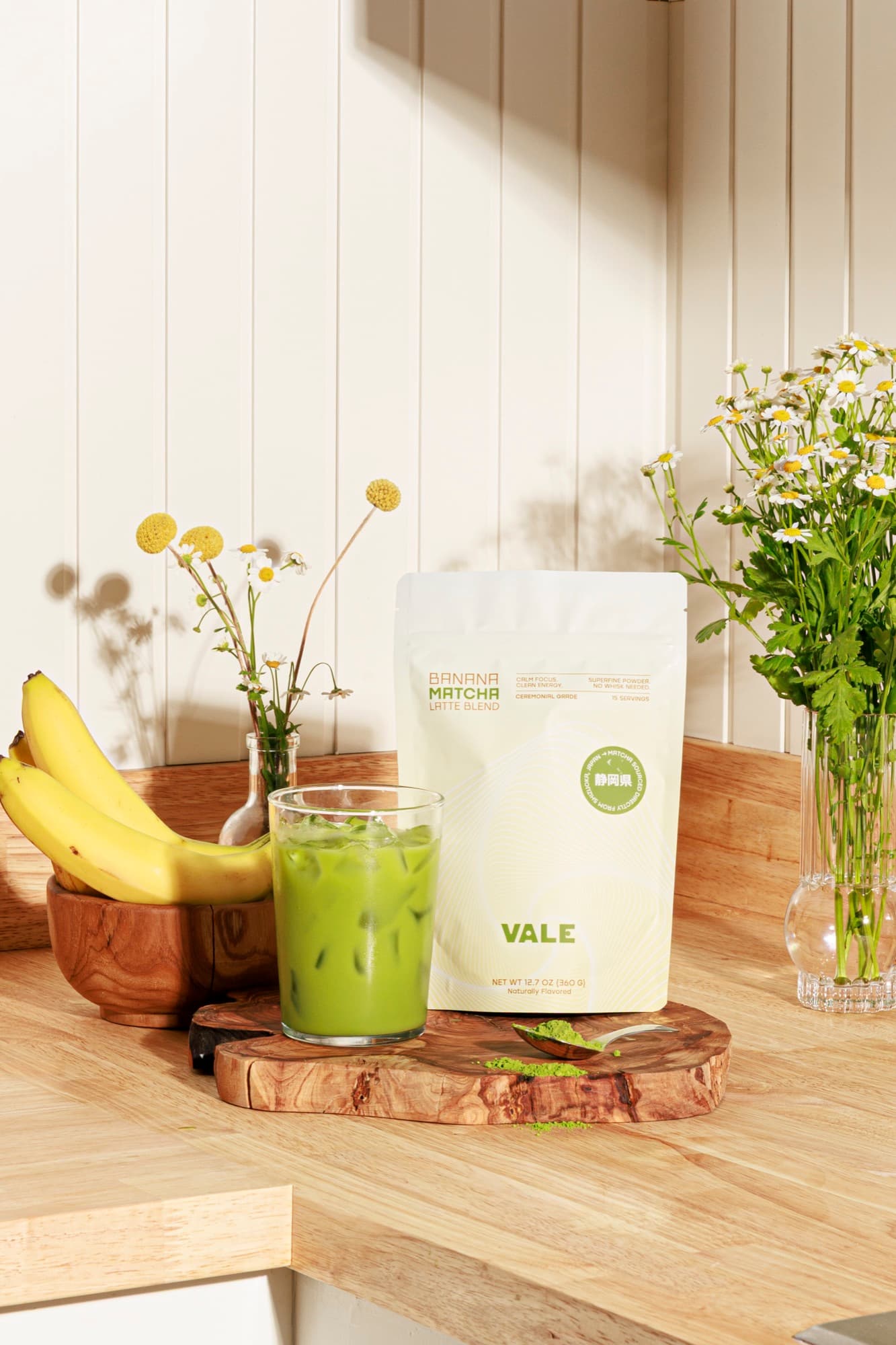 Banana Matcha Latte with fresh bananas and flowers in a sunny kitchen