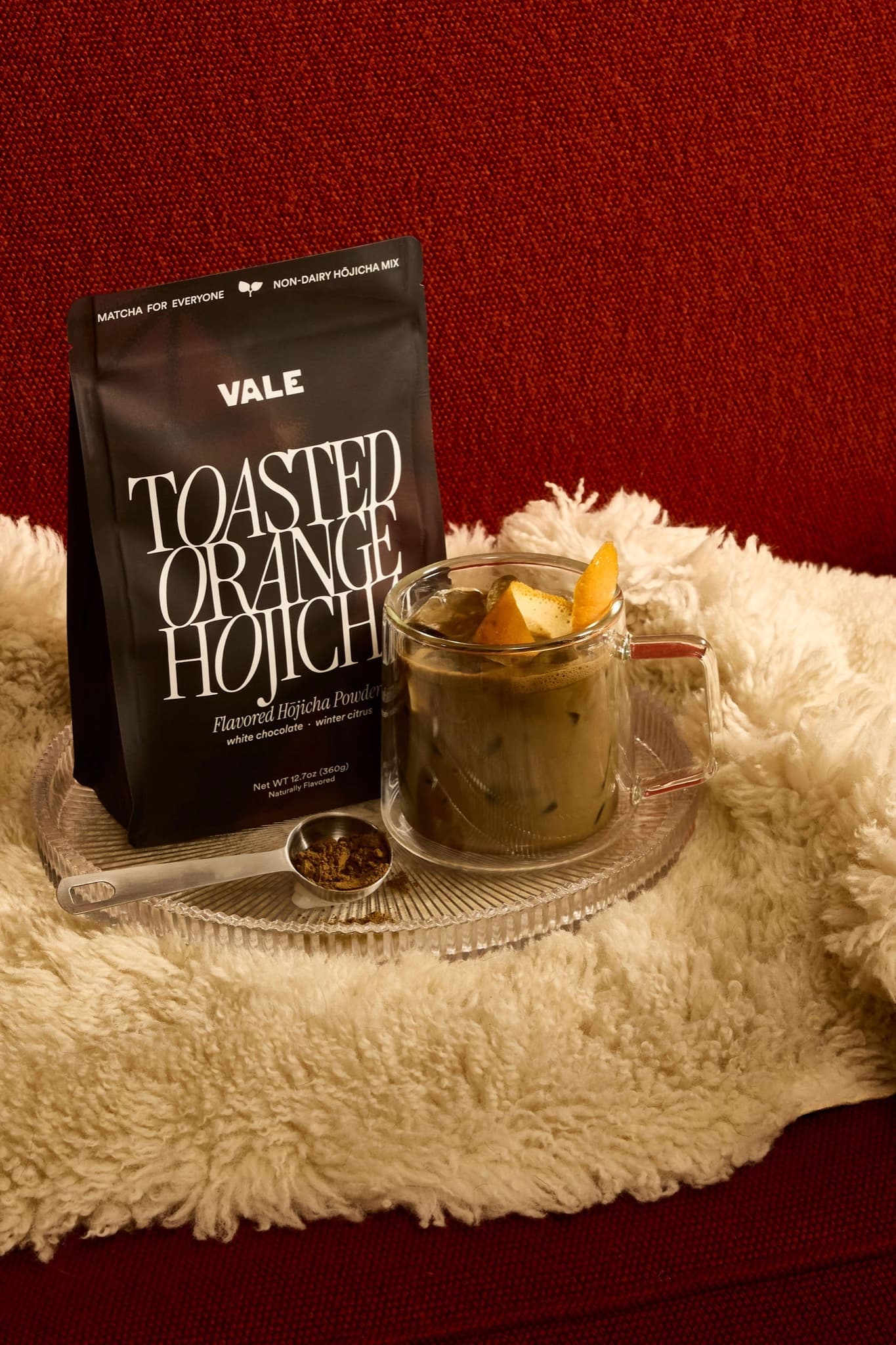 Vale Toasted Orange Hōjicha bag beside a hojicha latte with an orange twist