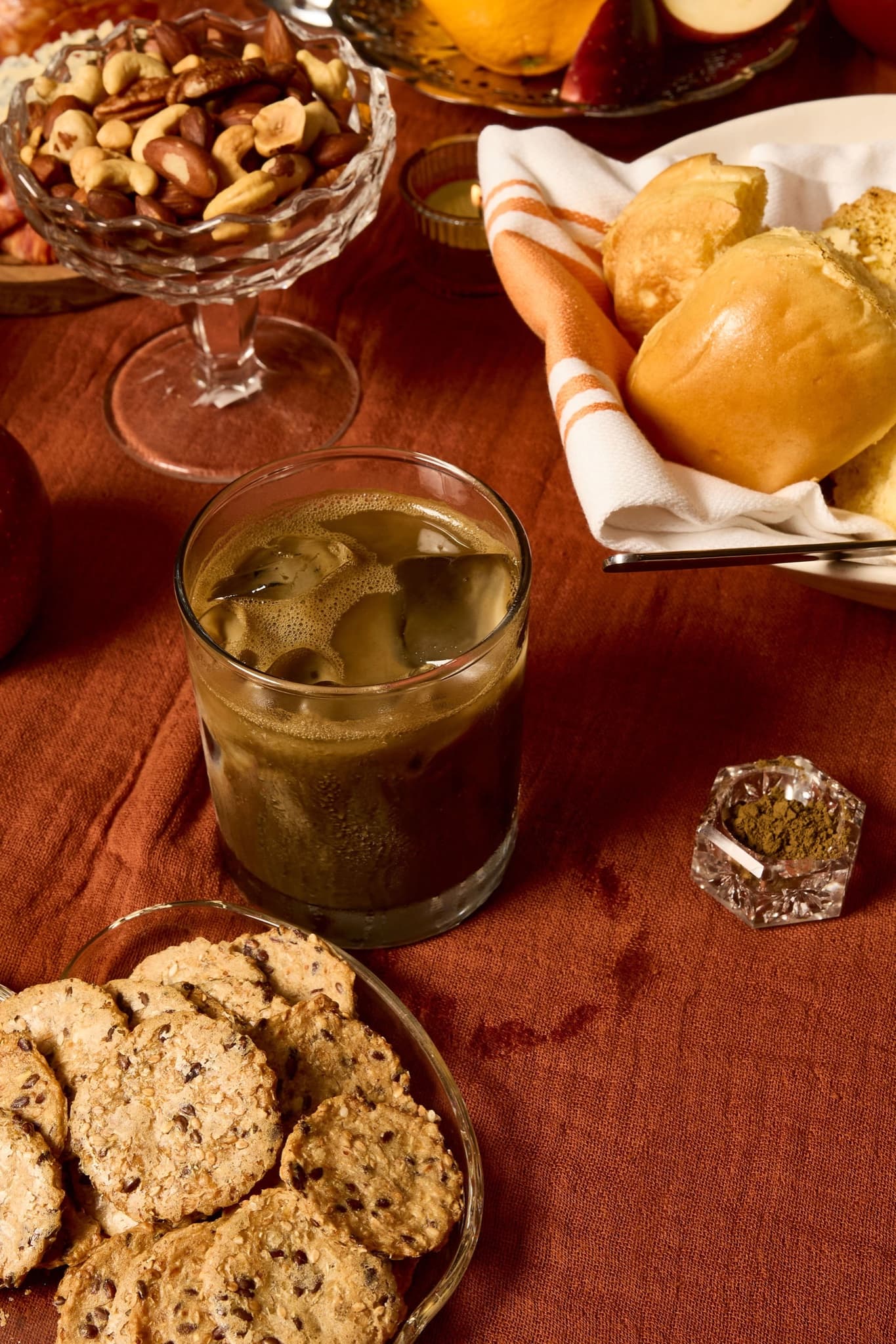Iced hojicha latte on a fall table with cookies and nuts