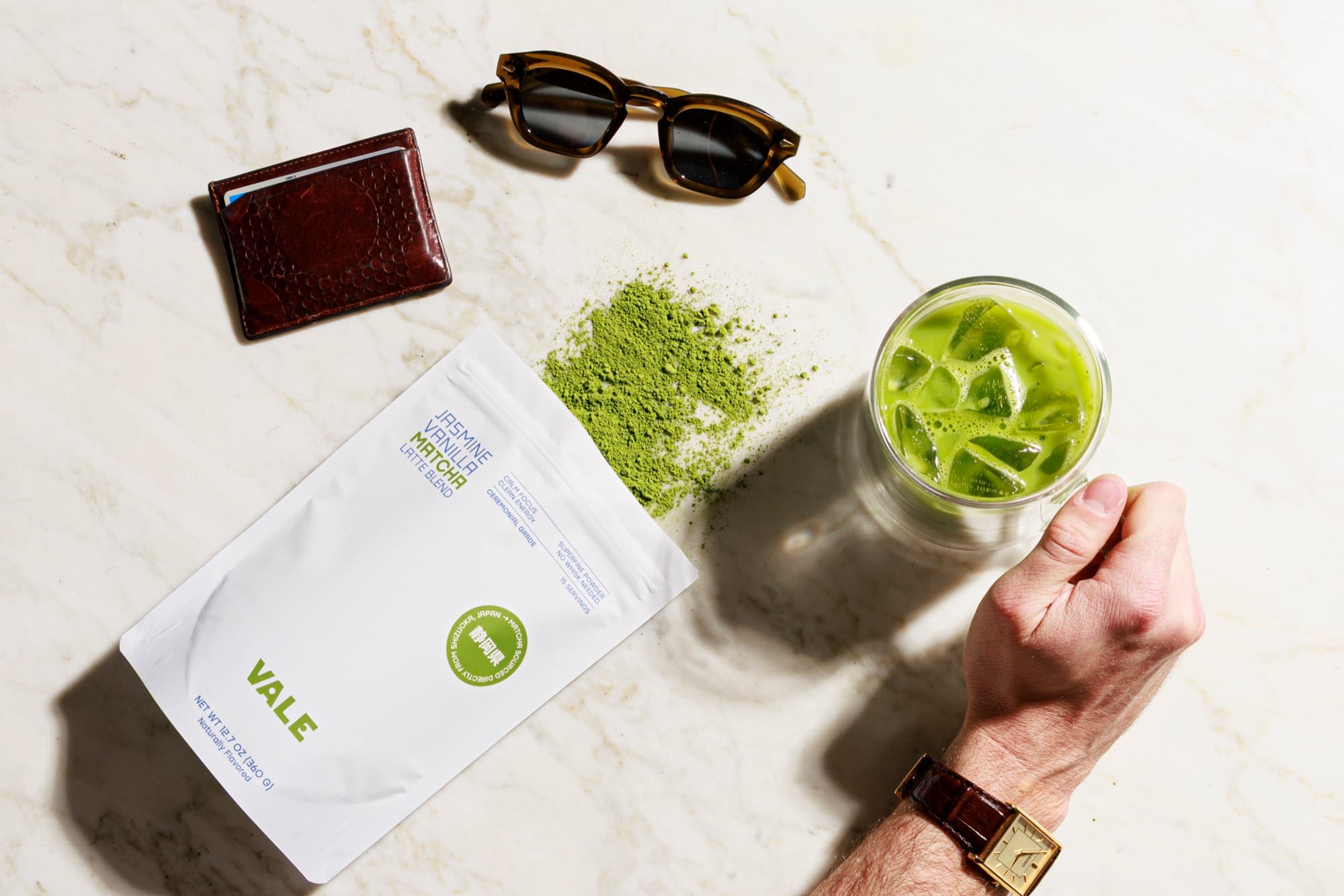 Jasmine Vanilla Matcha Latte flat lay with sunglasses and iced matcha on marble