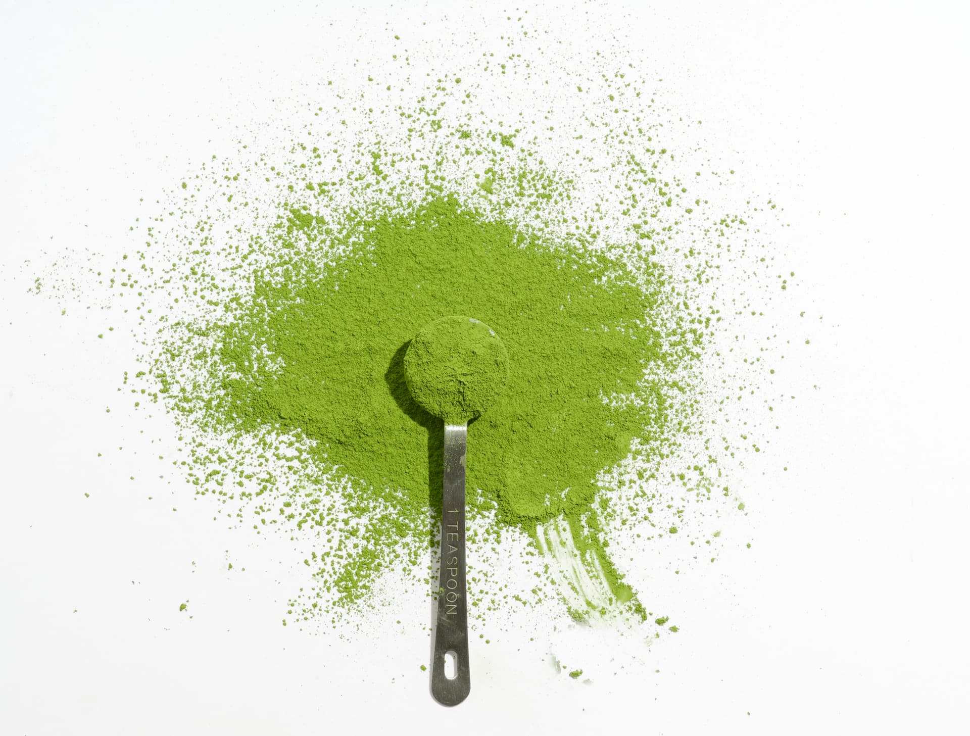 Vibrant green ceremonial matcha powder with measuring scoop