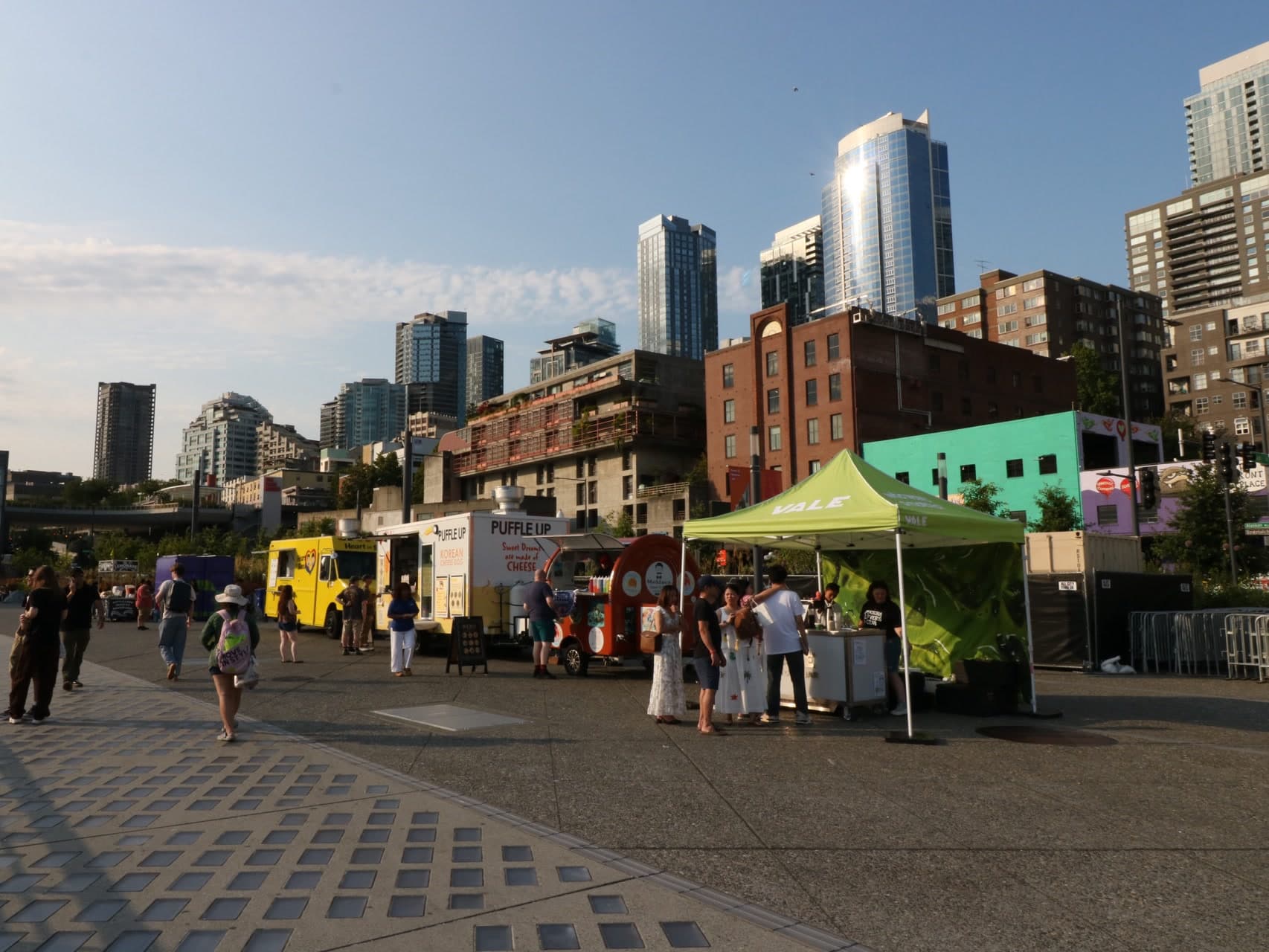 Vale Matcha Bar tent at Waterfront Park on Alaskan Way, with guests in line and the Seattle skyline behind it