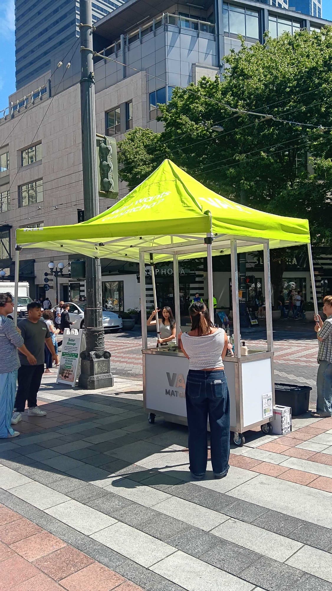 Vale Matcha Bar cart under a lime canopy at Westlake Center plaza in downtown Seattle, with a customer at the counter